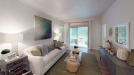 This single-floor residence offers a thoughtfully designed layout that balances comfort and functionality across its living spaces. The living room serves as a welcoming centerpiece, featuring wood-look flooring, crown molding, and a sliding glass door that floods the space with natural light and provides access to an outdoor patio area. A large statement artwork anchors the room, adding a bold visual focal point.

The galley-style kitchen is efficiently laid out with crisp white cabinetry, white countertops, a stainless steel sink, and stainless steel appliances including a full-size refrigerator and dishwasher. Light wood-look flooring runs the length of the kitchen, enhancing its bright and clean aesthetic.

Multiple bedrooms are present, each featuring plush carpeting, ceiling fans with lighting, and generous windows dressed with blinds and curtain panels that invite natural light while offering privacy. The master bedroom connects directly to its own bathroom, which boasts a double-sink vanity with white cabinetry, a large mirror with overhead lighting, and a shower-tub combination with tile surround. A second bathroom mirrors the same clean, modern aesthetic with hardwood-style flooring and ample vanity storage. The overall ambiance is light, airy, and move-in ready.