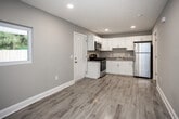 Located at 2300 Davenport Rd in Knoxville, Tennessee, this single-floor space has been thoughtfully updated with clean, contemporary finishes throughout. Light wood-look luxury vinyl plank flooring flows seamlessly across the entire space, complementing the soft gray-green wall tones and crisp white trim that define the interior's cohesive aesthetic.

The kitchen is a standout feature, outfitted with white shaker-style cabinetry, granite-look countertops, a stainless steel sink, and a full suite of stainless steel appliances including a refrigerator, electric range, and over-the-range microwave. The layout is efficient and well-appointed, with direct access to additional areas of the space.

The main living areas are open and well-lit, each equipped with ceiling fans with light fixtures. A wall-mounted HVAC unit provides climate control in one of the rooms, which also benefits from a large window offering views of the surrounding lush, mature tree canopy — bringing a sense of calm and natural beauty indoors.

The bathroom features classic penny-round tile flooring, a vanity with granite-patterned countertop, and clean, neutral walls — providing a polished, functional space. Recessed lighting and an attic access panel are also noted features of the interior.

Overall, this space presents a clean, move-in-ready environment with modern updates and a tranquil natural backdrop.