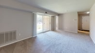 Located at 200 Stone Mill Rd in Lancaster, PA, this single-floor unit offers a straightforward, functional layout designed for comfortable everyday living. The floor plan, visible in the overhead view, reveals a well-organized arrangement of living, sleeping, kitchen, and bathroom spaces connected by a central corridor.

The living area is one of the most notable spaces, featuring plush wall-to-wall carpeting and neutral gray walls that create a calm, understated atmosphere. A large sliding glass door floods the room with natural light and provides direct views of the surrounding greenery outside, while vertical blinds offer privacy and light control. An HVAC vent overhead ensures year-round comfort.

The kitchen is equipped with warm-toned wood cabinetry, granite-style countertops, and a stainless steel refrigerator. Stone-look tile flooring adds durability and a clean, modern aesthetic to this functional space.

The bedrooms continue the carpeted flooring theme, each offering ample space and natural light from sizable windows fitted with horizontal blinds. The rooms feature neutral tones and clean white trim throughout.

The bathroom includes a full-size soaking tub with a tiled surround and brushed nickel fixtures, presenting a clean and well-maintained appearance. Overall, the unit maintains a consistent, neutral palette throughout, lending itself well to a variety of décor styles.