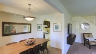 Located at 800 Trenton Road in Langhorne, Pennsylvania, this two-story residence offers a thoughtfully arranged layout designed for comfortable everyday living. The dining area serves as a welcoming gathering space, featuring warm wood flooring, a stylish pendant light fixture that anchors the room, and a generously sized dining table with ample seating. Framed botanical artwork adorns the clean, white walls, adding a touch of personality to the space.

A distinctive arched entryway connects the dining area to the kitchen, providing an elegant architectural detail that enhances the open flow between rooms. The kitchen is equipped with white appliances, dark cabinetry, and a light-tiled floor, creating a classic contrast that is both practical and visually appealing. The layout allows for efficient use of the cooking space while maintaining a clear sightline to the adjoining living and dining areas.

The living area, partially visible from the dining room, continues the neutral color palette with light walls and carpeted flooring, contributing to a cohesive and relaxed ambiance throughout the home. The overall interior design emphasizes simplicity and functionality, with clean lines and an uncluttered aesthetic. Spanning two floors, this residence provides well-distributed living space suited to a variety of lifestyles.