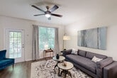 This two-story, two-bedroom, three-bathroom home in East Point, Georgia offers a thoughtfully designed layout spread across two floors. The main level features an inviting living room with hardwood-style flooring, a ceiling fan, and large windows that flood the space with natural light and offer views of surrounding greenery. A standout geometric accent wall in teal, taupe, and white anchors the dining area, adding a bold, artistic focal point adjacent to the staircase. The kitchen is well-appointed with white shaker-style cabinetry, granite-look countertops, and a full suite of stainless steel appliances, including a refrigerator, range, and over-the-range microwave. A convenient half bathroom completes the main level. Upstairs, the primary bedroom offers a comfortable, carpeted retreat with ample space, while the second bedroom features bright windows with garden views and plush carpet. Both upper-level bathrooms are finished with granite-top vanities and tiled tub-shower combinations. Two closets provide practical storage throughout. The home combines neutral tones with modern accents, creating a clean, contemporary ambiance suitable for a variety of lifestyles.
