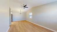 Located at 205 Warrior Dr in Murfreesboro, TN, this well-appointed 2-bedroom, 1-bathroom single-story home offers a clean, modern aesthetic throughout. Light-toned hardwood flooring flows consistently across all rooms, lending a bright and cohesive feel to the entire space.

The living area features a vaulted ceiling with a ceiling fan, adding a sense of openness and airflow. Adjacent to the living room, the dining area is highlighted by a stylish multi-arm chandelier and connects seamlessly to the kitchen, which includes white cabinetry and a stainless steel refrigerator.

The primary bedroom benefits from vaulted ceilings and dual windows that invite generous natural light and views of the surrounding neighborhood. The second bedroom is well-sized, with a closet and its own window. Both bedrooms are finished with the same warm hardwood flooring found throughout the home.

A dedicated laundry room houses the water heater and HVAC utilities, keeping mechanical systems neatly contained. The home also includes a closet for additional storage. Neutral gray walls throughout the home complement the light flooring, creating a calm, move-in-ready environment. Clean white trim and panel-style doors complete the polished, understated interior design.