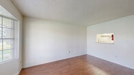 Located at 4601 Quail Hollow Dr in Baytown, Texas, this single-floor, two-bedroom, two-bathroom residence offers a practical and well-organized layout. Wood-look flooring runs throughout the home, providing a cohesive and easy-to-maintain surface across all main living areas. The textured ceilings are a consistent architectural detail found throughout the space.

The living room is an open, well-lit area featuring a distinctive bay window that allows natural light to fill the room. A convenient pass-through window connects the living and dining areas to the kitchen, enhancing the open feel of the shared spaces. The kitchen includes white cabinetry and a sink, visible through the pass-through opening.

The dining room sits adjacent to the main living area, creating a natural flow for everyday living. A dedicated laundry area adds functional convenience to the floorplan.

Both bedrooms feature wood-look flooring and windows with blinds that provide natural light and outdoor views. The primary bedroom is a well-proportioned space with its own closet. Each bathroom is cleanly finished in white, with a tub-shower combination, overhead cabinetry, and tile surround. Two closets throughout the home offer ample storage, including a walk-in closet with multi-level hanging rods.