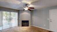 Located at 250 Crossbow Dr in Columbia, SC, this 2-bedroom, 2-bathroom single-story home offers a functional and comfortable layout. The living room serves as the heart of the space, featuring a tile-surround wood-burning fireplace, a ceiling fan with light fixture, soft carpet flooring, and a sliding glass door with vertical blinds that opens to an outdoor area and brings in natural light. The galley-style kitchen is outfitted with white cabinetry, light countertops, wood-look flooring, and stainless steel appliances, providing an efficient and clean workspace. The spacious primary bedroom is carpeted and connects to a generous walk-in closet with multi-level wire shelving for ample storage. The second bedroom also features carpet flooring and a window with natural light. Both bathrooms include gray-toned walls and wood-look tile flooring, with one bathroom featuring a full tub-shower combination finished with white subway tile surround. Throughout the home, neutral gray walls, textured ceilings, and consistent flooring choices create a cohesive and understated aesthetic suited for a variety of interior styles.