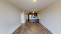 Located at 1333 N Wells Street in Chicago's sought-after Old Town neighborhood, this modern single-floor unit offers a clean, contemporary design with quality finishes throughout. The open-concept living and kitchen area is anchored by rich hardwood-style flooring that flows seamlessly through the main living spaces, creating a cohesive and inviting atmosphere.

The kitchen is a standout feature, equipped with stainless steel appliances including a gas range, microwave, and refrigerator. Dark espresso cabinetry reaches to the ceiling for ample storage, while a teal glass tile backsplash adds a pop of color. Light quartz countertops and a deep single-basin sink with a modern faucet complete the functional workspace. A peninsula-style counter provides additional prep space and separates the kitchen from the living area.

The living area benefits from large floor-to-ceiling windows that invite generous natural light and offer views of the surrounding Chicago skyline and neighborhood. The bedroom is well-proportioned with hardwood-style floors and direct access to adjacent rooms.

The bathroom is finished with large-format marble-look tile in the shower-tub surround, dark tile flooring, a white quartz vanity, and a wall-mounted cabinet for additional storage. A conveniently located in-unit laundry closet with louvered doors adds everyday practicality to this well-appointed urban residence.