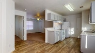 Located at 409 Riverhill Loop in Laredo, Texas, this single-floor unit offers a functional and well-organized layout designed for comfortable everyday living. The living area is finished with warm carpeting and features a ceiling fan with light fixture, creating a comfortable and airy atmosphere. A pass-through counter connects the living space to the kitchen, enhancing the open feel of the common areas. The kitchen is thoughtfully designed in a galley style, featuring wood-look flooring, gray cabinetry with ample storage, light-toned countertops, and a full suite of white appliances including a refrigerator, electric range with oven, and dishwasher. Natural light filters in through multiple windows fitted with blinds throughout the unit. The bedrooms are carpeted and well-proportioned, each with a window that allows natural light to brighten the space. Two bathrooms serve the unit, each finished with gray cabinetry, marble-style countertops, a single vanity sink with mirror, and a shower-tub combination. One bathroom features wood-look flooring for a cohesive aesthetic. The overall color palette is clean and neutral, with white walls and light trim creating a bright, move-in-ready environment throughout.