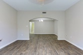 Located in the 30327 zip code of Atlanta, GA, this single-floor residence offers a thoughtfully designed layout with a cohesive neutral palette throughout. Rich wood-look flooring flows through the main living areas and hallways, complemented by clean white trim and soft taupe walls that create a warm, inviting ambiance. The living area is anchored by a striking arched passage that leads into a secondary space, adding architectural character to the open layout. French doors allow natural light to fill the room, enhanced by a ceiling fan overhead.

The kitchen is outfitted with crisp white shaker cabinetry, granite countertops, a tile backsplash, and an L-shaped peninsula that provides generous prep and storage space. Tile flooring grounds the kitchen, distinguishing it from the rest of the home.

The bedrooms feature plush carpeting and large windows that frame green outdoor views, offering a peaceful retreat. Ceiling fans add comfort to the primary bedroom. The bathrooms are finished with granite-topped double vanities, white cabinetry, and a soaking tub with tiled surround. A dedicated laundry room with full-size washer and dryer hookups and built-in shelving adds everyday convenience to this well-rounded Atlanta home.