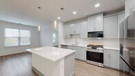 Located at 286 Main St in Madison, NJ, this thoughtfully designed one-bedroom-plus-study residence offers a clean, contemporary aesthetic throughout its single-floor layout. The open-concept living area seamlessly connects the dining room, kitchen, and living room, creating a bright and cohesive space ideal for both everyday living and entertaining. The kitchen is a standout feature, showcasing soft gray shaker cabinetry, a herringbone tile backsplash, quartz countertops, a large center island with pendant lighting, and a full suite of stainless steel appliances including a gas range, built-in microwave, dishwasher, and French door refrigerator. Light wood-tone flooring flows consistently throughout the residence, enhancing the airy, modern feel. The spacious primary bedroom offers a generous footprint with a double-door closet, while the secondary room functions well as a study or guest room, featuring natural light from a window with blinds. Four closets total provide ample storage throughout. The full bathroom is finished in crisp white tile with a sliding glass tub-shower enclosure and a gray vanity with a large mirror. In-unit laundry adds everyday convenience to this well-appointed Madison residence.