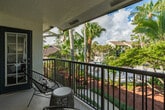 Located at 1212 Town Lakes Dr in Boca Raton, FL, this well-appointed one-bedroom, one-bathroom residence offers a thoughtfully designed layout across a single floor. Light wood flooring flows throughout, complementing the neutral color palette and creating a warm, cohesive aesthetic.

The living room is a bright, inviting space anchored by expansive windows that frame lush tropical palm views, flooding the room with natural light. A glass door leads directly to the private balcony, seamlessly connecting indoor and outdoor living. 

The kitchen is efficiently designed with rich cherry wood cabinetry, stainless steel appliances, a mosaic tile backsplash, track lighting, and a peninsula counter with bar seating — ideal for casual dining or entertaining.

The bedroom is a comfortable retreat with light wood flooring, generous closet space, and direct access to the bathroom. The bathroom features warm wood vanity cabinetry, a light stone countertop, a framed mirror, and a separate tiled tub and shower area finished in clean white.

Two closets provide ample storage throughout the residence. The private balcony offers an outdoor escape surrounded by the lush Florida greenery that defines this Boca Raton community.
