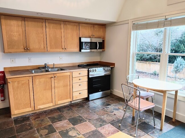 Galley kitchen with dining area. New in 2023: Microwave and range w radiant burners and air fryer - 411 N Geneva St