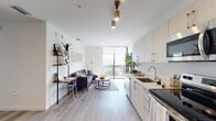 Located at 1621 NW 15th St in Miami's vibrant urban core, this single-floor residence showcases a clean, contemporary design with a neutral palette and light wood-style flooring throughout. The open-plan layout seamlessly connects the kitchen, dining, and living areas, creating a cohesive and functional space. The kitchen is outfitted with light-toned flat-front cabinetry, quartz countertops, stainless steel appliances—including a range, microwave, dishwasher, and refrigerator—and an undermount sink. A dedicated dining nook accommodates a round glass table, while the living area is anchored by large floor-to-ceiling windows and balcony access, filling the space with natural light and offering open city views. Track lighting and pendant fixtures provide modern illumination throughout. The two bedrooms each feature large windows with Miami skyline views, wood-style flooring, and closet storage. Both bathrooms are finished consistently, with light wood-tone vanities, quartz counters, subway-tiled shower surrounds, and wood-style tile flooring. The overall ambiance is bright, modern, and well-appointed.