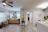 Located at 10770 Barely Lane in Houston, TX, this thoughtfully designed single-floor residence offers a cohesive open-concept layout connecting the living room, dining area, and kitchen into one welcoming, light-filled space. Light wood-look flooring flows throughout the main living areas, complemented by neutral gray walls and ceiling fans that enhance comfort and airflow.

The kitchen is outfitted with white cabinetry, light gray tile backsplash, white quartz countertops, and a full suite of stainless steel appliances, including a range, microwave, dishwasher, and refrigerator. A peninsula counter connects the kitchen to the dining and living areas, ideal for casual dining or entertaining. The living room provides a bright and airy atmosphere with a window offering natural light.

The generously sized primary bedroom features plush carpeting, a ceiling fan, and ample room for a workspace, along with access to multiple closets for excellent storage. The bathroom includes a full tub-shower combination with a curved curtain rod and white cabinetry overhead.

Practical amenities include a dedicated in-unit laundry area housing a full-size washer and dryer with built-in shelving. Three closets throughout the unit provide abundant storage, rounding out this efficient and comfortable Houston residence.