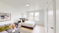 Located at 2217 N 51st St in Philadelphia's Wynnefield neighborhood, this one-bedroom, one-bathroom unit offers a thoughtfully designed layout that makes efficient use of its compact footprint. Light wood flooring flows throughout, lending warmth and visual continuity to the entire space.

The generously sized bedroom serves as the heart of the unit, accommodating both a sleeping area and a sitting area with ease. A large window admits abundant natural light and provides views of the surrounding neighborhood, while a radiator ensures year-round comfort. Clean white walls create a bright, airy atmosphere.

The kitchen is crisp and modern, featuring white cabinetry with matte black hardware, sleek marble-look countertops, a stainless steel sink with a black gooseneck faucet, and a gas range. A sizable window above the counter fills the space with natural light, enhancing the clean aesthetic.

The bathroom continues the light and minimal design language, with white subway tile, a white vanity topped with a rounded mirror, matte black fixtures, and a window that provides both ventilation and natural light. A hallway connects the rooms, providing practical flow through the unit.

Overall, this unit presents a cohesive, modern interior with carefully chosen finishes throughout.