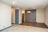 This efficiently designed one-bedroom, one-bathroom unit offers a thoughtful layout across a single floor, making excellent use of every square foot. The open living area greets you upon entry, featuring plush carpet flooring, neutral-toned walls, and a textured ceiling. Recessed lighting and a striking crystal chandelier add a touch of elegance to the space, while a window fitted with blinds allows natural light to filter in. The living area transitions seamlessly into the kitchen via wood-look vinyl plank flooring. The galley-style kitchen is well-equipped with stainless steel appliances — including a refrigerator, stove, and dishwasher — complemented by crisp white shaker cabinetry, dark countertops, and recessed lighting overhead. The bedroom is a comfortable, carpeted retreat with a window offering an outdoor view and a dedicated closet with paneled doors. A hallway connects the spaces efficiently. The full bathroom features a tub-shower combination, a vanity with a granite-style countertop and framed mirror, wood-look flooring, and brushed nickel fixtures throughout, completing this clean and modern unit.