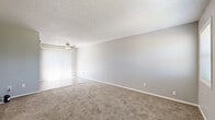 Located at 2902 S Bunker Hill in Wichita, Kansas, this single-floor, 2-bedroom, 1-bathroom unit offers a practical and well-organized layout. The interior is finished with a consistent neutral gray color palette and white trim throughout, creating a clean, cohesive look.

The living area features plush carpeting, a textured ceiling, and a ceiling fan, with large vertical-blind-covered windows that allow natural light to fill the space. The galley-style kitchen is thoughtfully designed with gray cabinetry featuring scalloped detailing, dark granite-style countertops, black appliances including a range and refrigerator, a stainless steel sink, and wood-look vinyl plank flooring—providing both functionality and style.

The spacious primary bedroom includes a ceiling fan, carpeted flooring, and multiple windows fitted with blinds. The second bedroom is similarly carpeted and benefits from natural light via a window with blinds. Both rooms offer ample wall space for flexible furniture arrangements.

The full bathroom is efficiently laid out with a gray vanity, white countertop, a mirrored medicine cabinet, a tub/shower combo, and matching wood-look vinyl plank flooring, tying together the unit's consistent design aesthetic.