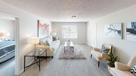 This single-floor residence offers a thoughtfully designed layout that balances comfort and functionality. The living room is a welcoming, open space featuring light wood-style flooring, a textured ceiling, and a large window fitted with blinds that allow natural light to fill the room. A bold, colorful wall canvas adds a vibrant focal point to the area.

The galley-style kitchen is efficiently arranged with white cabinetry, stainless steel appliances including a refrigerator, electric range, and over-the-range microwave, along with a double-basin sink and ample counter space. The adjacent dining area accommodates a round glass-top table with seating for four, complemented by a ceiling fan with integrated lighting and a nearby built-in storage closet.

Both bedrooms are generously sized with the same light wood-style flooring, neutral gray walls, and textured ceilings. Each room benefits from natural light through window treatments. One bedroom conveniently houses a stacked washer and dryer unit. The two bathrooms are cleanly finished, each featuring a tub-shower combination, wood-style flooring, and vanity storage. The overall aesthetic is modern and neutral, creating a bright, cohesive atmosphere throughout the home.