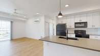 Located at 311 E Rio Grande St in Colorado Springs, CO, this modern 2-bedroom, 2-bathroom unit offers a thoughtfully designed single-floor layout with a clean, contemporary aesthetic throughout. The open-concept living and kitchen area is anchored by light wood-tone flooring, crisp white walls, and recessed lighting, creating a bright and airy atmosphere. A ceiling fan and sliding glass door lead to a private balcony, bringing in natural light and outdoor views. The kitchen is a standout feature, equipped with a large peninsula island topped with a quartz-style countertop, an undermount sink with a matte black faucet, white shaker cabinetry, subway tile backsplash, and black stainless steel appliances, all accented by sleek pendant lighting. Both bedrooms are carpeted and equipped with individual wall-mounted mini-split HVAC units for personalized climate control. The primary bedroom includes a closet, while the second bedroom features a window with natural light. The bathrooms are finished with large-format tile flooring, white vanity cabinetry, and a tub-shower combo with bold dark tile surround and matte black fixtures. A dedicated laundry area and two closets complete this efficiently designed, move-in ready home.