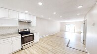 Located at 52 Perry Hill Rd in Ashford, CT, this two-story, 2-bedroom, 2-bathroom home offers a clean, modern aesthetic throughout. The main floor features an open-concept kitchen and living area with light hardwood-style flooring, recessed lighting, and a textured ceiling. The kitchen is well-appointed with white shaker cabinetry, granite countertops, a mosaic tile backsplash, and a full suite of stainless steel appliances including a refrigerator, electric range, and dishwasher. The adjacent living area is bright and open, benefiting from natural light and a sliding glass door that leads to an outdoor deck. A bathroom on this level includes a stylish vanity with granite countertop, mirrored medicine cabinet, marble-style tile flooring, and in-unit washer and dryer. Upstairs, two well-sized bedrooms are finished with the same light wood flooring and neutral warm-toned walls. The spacious primary bedroom includes a closet, while both rooms offer views of the surrounding wooded landscape through generous windows. A second full hallway bathroom serves the upper level. Two closets provide ample storage throughout the home, and the overall design presents a fresh, move-in-ready living space.