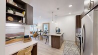 Located at 3939 W 12th St in Houston, TX, this thoughtfully designed one-bedroom, one-bathroom residence offers a modern open-concept layout with stylish finishes throughout. Light wood-style flooring runs continuously across the main living area, enhancing the sense of openness and flow.

The kitchen is a standout feature, showcasing dark walnut-toned cabinetry extending to the ceiling, quartz countertops, a subway tile backsplash, and stainless steel appliances including a refrigerator, range, and microwave. A kitchen island with bar seating and elegant brass pendant lighting serves as both a functional workspace and a casual dining area, seamlessly connecting the kitchen to the living space.

The living room benefits from natural light via full-height glass doors with outdoor views, complemented by recessed lighting and a ceiling fan. A dedicated workspace area with built-in shelving adds practical utility.

The bedroom is a calm retreat with a large window offering natural light, plush carpeting, and direct access to a closet. The bathroom features a full soaking tub and shower combination with clean tile surrounds in neutral tones. Every detail of this residence reflects a cohesive, contemporary design aesthetic well-suited for modern urban living.