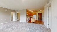 This single-floor residence is designed with a functional, open layout that connects the living area to the kitchen, creating a cohesive and practical living space. The living area features neutral-toned carpet, offering a comfortable and versatile foundation, while multiple windows allow natural light to fill the space.

The kitchen is well-appointed with warm honey-toned wood cabinetry extending to the upper walls, providing generous storage. White appliances—including a refrigerator, electric range, over-the-range microwave, and dishwasher—complement the light countertops. A central island offers additional prep and casual dining space, while durable hardwood-style flooring adds warmth and easy maintenance to this area.

The bedrooms are carpeted and generously sized, each featuring large windows that bring in natural daylight and outward views. The rooms offer clean, neutral walls suitable for a variety of uses.

Two full bathrooms serve the unit, each finished consistently with warm wood vanity cabinetry, white countertops, large mirrors, tiled flooring, and a shower-tub combination, presenting a clean and cohesive aesthetic throughout.