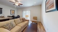Located at 977 Grove Blvd in Florence, South Carolina, this two-floor residence offers a well-organized layout with thoughtfully appointed finishes throughout. Wood-look flooring runs consistently across the living areas and bedrooms, contributing to a cohesive and clean aesthetic.

The main living area is bright and open, featuring recessed lighting, a ceiling fan, and a sliding glass door that brings in natural light and provides outdoor access. An adjacent dining area completes the space, making it functional for everyday living.

The kitchen is equipped with dark espresso cabinetry, granite countertops with warm tonal variations, stainless steel appliances including an electric range, built-in microwave, and a stainless undermount sink — a practical and attractive combination.

Multiple bedrooms are present across the two floors. The primary bedroom features vaulted ceilings, a ceiling fan, and a window with blinds offering natural light. Additional bedrooms are similarly sized, each with windows and wood-look flooring.

Bathrooms are finished consistently with dark vanity cabinetry, granite countertops, and light flooring. One bathroom includes a tub-shower combination, while a secondary half-bath serves the lower level. The overall design is clean, neutral, and move-in ready.