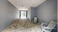 Located at 2810 University Square Dr in Tampa, Florida, this single-floor residence is part of a modern, multi-story community characterized by bold exterior color contrasts — deep blues, greens, and crisp whites — clad in horizontal lap siding. The unit includes a generously sized primary bedroom and a connecting hallway, finished with warm wood-look flooring and classic wainscoting that lends a polished, welcoming feel throughout.

The interior hallway is bright and well-proportioned, featuring clean white walls with paneled wainscoting and natural light drawing you toward the unit entrance, marked by a charming "hello" doormat. The primary bedroom offers a comfortable and sizeable personal retreat within the overall floor plan.

The community's shared outdoor spaces are a true highlight. Beautifully landscaped courtyards feature herringbone-patterned brick walkways, swaying palm trees, lush tropical plantings, and manicured turf. Residents can enjoy hammock lounging areas, an outdoor kitchen with a built-in grill and sink, dining seating, string lights, and a giant checkerboard game area. Covered breezeway passages with Adirondack seating connect the buildings and open directly to these inviting outdoor amenity zones, making the overall living environment feel both social and resort-inspired.