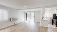 This 440 square foot studio apartment, located at 132 S Robertson Blvd in Los Angeles, offers a contemporary living space designed for efficiency and comfort. The open-concept floor plan maximizes the available area, seamlessly blending the living room and kitchen into one cohesive space. Light wood laminate flooring runs throughout, creating a sense of continuity and enhancing the apartment's bright, airy ambiance.

The kitchen, while compact, is well-equipped with modern appliances including a stainless steel refrigerator, oven, and built-in microwave. White cabinetry lines the walls, providing ample storage, while a small countertop offers workspace for meal preparation. The living area is spacious enough to accommodate essential furniture and features recessed lighting and a wall-mounted air conditioning unit for climate control.

Large windows and a sliding glass door flood the space with natural light, creating an illusion of a larger area. The glass door leads to a small outdoor space, perfect for enjoying fresh air or potentially adding some greenery. The apartment's clean, white walls serve as a blank canvas for personalization, allowing residents to easily adapt the space to their style preferences.