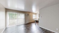 Located at 2890 S Ninth St in Kalamazoo, MI, this two-bedroom, one-bathroom unit offers a practical and well-appointed single-floor layout. The open-concept living, dining, and kitchen area serves as the heart of the home, featuring dark hardwood-style flooring that flows throughout. Large sliding glass doors flood the living area with natural light and provide direct outdoor access, complemented by a wall-mounted air conditioning unit and baseboard heating. The kitchen is well-equipped with rich dark cabinetry, generous counter space, stainless steel appliances including a refrigerator and electric range, and a peninsula that doubles as a dining surface — ideal for everyday use. Both bedrooms are carpeted for comfort and include natural light from windows with blinds. The primary bedroom offers built-in closet storage, while the unit overall boasts an impressive six closets for ample organization. The full bathroom features a tub/shower combo, a dark-cabinetry vanity with a clean white countertop, and wood-look flooring. Neutral wall tones throughout create a bright, cohesive ambiance, making this a functional and move-in ready space.