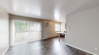 Located at 2890 S Ninth St in Kalamazoo, MI, this two-bedroom, one-bathroom unit offers a practical and well-appointed single-floor layout. The open-concept living, dining, and kitchen area serves as the heart of the home, featuring dark hardwood-style flooring that flows throughout. Large sliding glass doors flood the living area with natural light and provide direct outdoor access, complemented by a wall-mounted air conditioning unit and baseboard heating. The kitchen is well-equipped with rich dark cabinetry, generous counter space, stainless steel appliances including a refrigerator and electric range, and a peninsula that doubles as a dining surface — ideal for everyday use. Both bedrooms are carpeted for comfort and include natural light from windows with blinds. The primary bedroom offers built-in closet storage, while the unit overall boasts an impressive six closets for ample organization. The full bathroom features a tub/shower combo, a dark-cabinetry vanity with a clean white countertop, and wood-look flooring. Neutral wall tones throughout create a bright, cohesive ambiance, making this a functional and move-in ready space.