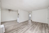 This 720 square foot apartment in El Cajon, CA, offers a well-designed living space with two bedrooms and one bathroom. The primary bedroom, measuring 150 square feet, provides ample space for a comfortable retreat. The apartment features a neutral color palette with crisp white walls and ceilings, creating a bright and airy atmosphere throughout.

The living areas are adorned with plush beige carpeting, while the kitchen and bathroom showcase durable wood-look flooring. Large windows in the bedrooms and living area allow natural light to flood the space, enhancing the overall ambiance. The kitchen is efficiently designed with white cabinetry, providing ample storage, and is equipped with essential appliances including a refrigerator, dishwasher, and range.

The bathroom features a modern design with a sliding glass shower door and a vanity for storage. Built-in closets in the bedrooms offer additional storage solutions. The apartment's layout maximizes the use of space, creating a functional and comfortable living environment. Located at 233 Shady Ln, this single-story unit combines practicality with modern aesthetics, making it an ideal home for those seeking a cozy yet contemporary living space.