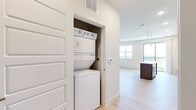 Located at 707 W Slaughter Ln, Unit 573 in Austin, TX, this two-bedroom, one-bathroom residence offers a well-designed single-floor layout with a clean, modern aesthetic throughout. Light wood-tone flooring runs continuously across all rooms, lending a cohesive and airy feel to the space.

The open-concept kitchen serves as a central hub, featuring white upper cabinetry, dark wood-toned lower cabinets and a matching island with a white quartz-style countertop, pendant lighting, a subway tile backsplash, and stainless steel appliances including a refrigerator with ice maker, range, microwave, and dishwasher. The adjoining living area benefits from a ceiling fan, recessed lighting, and a sliding glass door that opens to a balcony with expansive outdoor views.

Both bedrooms are bright and well-proportioned, each equipped with a ceiling fan and windows fitted with horizontal blinds that frame views of the surrounding landscape. The primary bedroom offers a comfortable footprint with panel-style doors and clean neutral walls.

The bathroom is efficiently laid out with a long, dark wood vanity unit topped with a white countertop, a large mirror, recessed lighting, and a full tub-shower combination. The overall design prioritizes functionality and a contemporary, neutral palette.