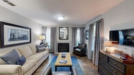 Located at 1 Magnolia Cir in Jonesboro, GA, this single-story, 2-bedroom, 1-bathroom home offers a thoughtfully arranged layout across one level. The living room serves as the heart of the home, featuring a fireplace flanked by windows with panel drapes, wood-style flooring, and a textured ceiling that adds character throughout. Natural light filters in through multiple windows, creating a warm and inviting ambiance. The living and dining areas flow together seamlessly, with the dining space showcasing a pendant light fixture and easy access to a closet and hallway. The galley-style kitchen is well-appointed with white cabinetry, mosaic tile backsplash, black appliances, and ample counter space, along with a window that brings in additional natural light. The primary bedroom offers a comfortable, carpeted retreat with a window and room for generous furnishings. The second bedroom also features carpet and a window, providing a versatile space suitable for various needs. The bathroom includes a tub-shower combination, a wide vanity with a light countertop, a large mirror, and wood-style flooring. A hallway and closet complete the functional layout of this well-designed Jonesboro home.