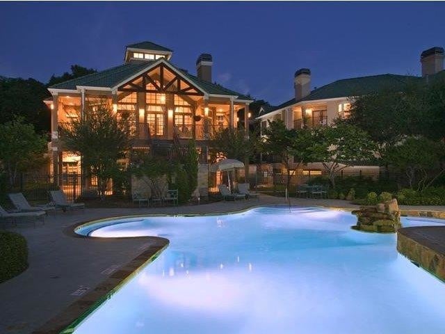 Nighttime pool view with clubhouse in the background - Canyon Springs at Bull Creek