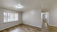 Located on Martin Luther King Jr Blvd in Houston, Texas, this single-story, 2-bedroom, 1-bathroom home offers a straightforward and functional layout. The living room features wood-look plank flooring and neutral walls, with an open sightline connecting to the hallway and kitchen area, creating a cohesive flow throughout the main living spaces.

The galley-style kitchen is efficiently organized with gray cabinetry lining both sides, granite-look countertops, a double-basin stainless steel sink, a gas range, and a full-size refrigerator. Wood-look flooring continues through this space, maintaining visual consistency.

Both bedrooms are carpeted for comfort and feature textured ceilings and windows with blinds that allow for natural light. The primary bedroom is a well-proportioned space, while the second bedroom offers similar finishes and natural light through its window. Each bedroom benefits from access to one of the two dedicated closets.

The bathroom includes wood-look flooring, a single vanity with a granite-look countertop, and a tiled shower-tub combo. The textured walls and functional fixtures provide a clean, utilitarian finish throughout.

A connecting hallway ties all rooms together, providing organized circulation across the home's compact yet efficient floor plan.