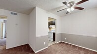 Located at 1312 Kilmer Way in Clarksville, Indiana, this one-bedroom, one-bathroom unit offers a practical and well-organized single-floor layout. The living room provides a comfortable gathering space with plush wall-to-wall carpeting, a ceiling fan with light fixture, and a two-tone wall treatment featuring a neutral upper tone and a contrasting lower half. A hallway connects the living area to the private bedroom and bathroom, creating a clear and functional flow throughout.

The kitchen is accessible directly from the living area and is equipped with dark cabinetry, a tile backsplash, light countertops, a white range, and wood-look flooring. The kitchen also houses the electrical panel. Adjacent to the kitchen, the living space includes additional room that can accommodate a dining arrangement.

The bedroom is generously sized, featuring soft carpeting, a window that allows natural light, and direct access to a dedicated walk-in closet with built-in shelving — a practical storage solution. The bathroom includes a full tub and shower combo with white tile surround and a chrome showerhead. Textured ceilings are consistent throughout the unit, adding a classic residential character to the overall interior.