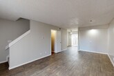 Located at 3324 S Field St in Lakewood, Colorado, this two-story home offers three bedrooms, two bathrooms, and a thoughtfully arranged layout spread across two floors. The main level features an open living and dining area with durable wood-look flooring, neutral gray walls, and a textured ceiling throughout. A ceiling fan accents the living area, which receives natural light through a sliding glass door fitted with vertical blinds. The galley-style kitchen is well-appointed with white shaker cabinetry, marble-look countertops, a gray subway tile backsplash, stainless steel appliances including a refrigerator and dishwasher, and a double-basin sink — all set over wood-look flooring. A staircase connects the main level to the upper floor, where three bedrooms are located. The bedrooms feature plush carpeting, neutral tones, and windows that bring in natural light. The primary bedroom is a comfortable, well-sized retreat. Both bathrooms include a tub-shower combination with clean white tile surround. The home's consistent use of neutral finishes, wood-look flooring on the main level, and carpet in the bedrooms creates a cohesive and move-in-ready aesthetic throughout.