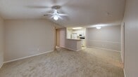 Located at 120 Amelia Forest Lane in Columbia, South Carolina, this single-story residence offers a well-organized, functional layout across a comfortable footprint. The open living and dining area serves as the heart of the home, featuring vaulted ceilings, a ceiling fan with light fixture, and neutral carpet flooring that extends throughout. A window provides natural light, while a glass-paned door offers access to the exterior. The kitchen is positioned adjacent to the main living space and is visible over a breakfast bar peninsula. Designed in a galley style, it features white cabinetry, light countertops, a double-basin sink, and white appliances including a refrigerator, electric range, dishwasher, and built-in microwave. Light tile flooring and ample upper and lower cabinet storage complete the space. The bedrooms are carpeted and include ceiling fans and windows with blinds. At least one bedroom features a walk-in closet with built-in shelving. The bathroom includes a wide vanity with an extended countertop, white cabinetry, a lighted mirror, a medicine cabinet, and a separate tub and shower combination. The overall aesthetic is clean and neutral throughout.
