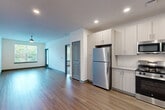 Located at 191 Commerce Dr in Villa Rica, Georgia, this well-appointed single-story home offers three bedrooms, two bathrooms, and a thoughtfully designed layout. The open-concept kitchen and living area serves as the heart of the home, featuring warm wood-look flooring, recessed lighting, and a ceiling fan. The kitchen is outfitted with light wood cabinetry extending to the ceiling for maximum storage, granite countertops, a subway tile backsplash, and a full suite of stainless steel appliances including a gas range, microwave, refrigerator, and dishwasher. The bedrooms are carpeted for comfort, each featuring natural light from large windows with blinds. The primary bedroom is generously sized and includes a walk-in closet with wire shelving on multiple walls, providing excellent organization capacity. Both bathrooms mirror each other in design, offering a tub-shower combination with tiled surround, wood-look flooring, granite-topped vanities, and modern wood-grain cabinetry. Three closets throughout the home ensure abundant storage. A connecting hallway ties the layout together efficiently, making this a practical and modern living space.