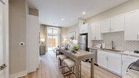 Located at 4021 Ridge Ave in Philadelphia's East Falls neighborhood, this well-appointed one-bedroom, one-bathroom residence offers a smart, efficient layout with high-quality finishes throughout. The open-concept living and kitchen area is anchored by light hardwood flooring and a neutral color palette that creates a warm, inviting ambiance. The kitchen is a standout, featuring crisp white shaker cabinetry, stone countertops, a classic subway tile backsplash, and a full suite of stainless steel appliances, including a refrigerator, electric range, and built-in microwave. A central dining table with bar seating serves as a natural divider between the kitchen and the living area, which benefits from access to an outdoor-facing window that draws in natural light. The bedroom is a serene retreat, accommodating a full-size bed with room to spare, and features large windows that invite generous daylight and outdoor views. The bathroom is finished with large-format marble-style tile flooring, a glass-enclosed walk-in shower, and a vanity with stone countertops. A well-organized walk-in closet is directly accessible from the bathroom. Additional conveniences include two laundry areas and two closets, rounding out a functional and refined living space.