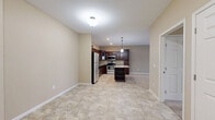 Located at 1015 Hope St in Mankato, MN, this single-floor residence offers a thoughtfully designed layout across two bedrooms and two bathrooms. The heart of the home is an open-concept living, dining, and kitchen area that flows seamlessly together. The kitchen is a standout feature, showcasing rich dark-wood cabinetry, granite countertops, stainless steel appliances, and a central island with pendant lighting overhead — ideal for both cooking and casual dining. Stone-tile flooring extends throughout the kitchen and into the living area, while plush carpet adds warmth to the living and bedroom spaces. The spacious living room receives natural light through a sliding glass door that leads to a private balcony. Both bedrooms are generously sized, with soft carpet, neutral walls, and ample closet space — four closets in total are distributed throughout the unit. The two bathrooms are finished consistently with dark-wood vanities, white countertops, and stone-tile flooring. A dedicated utility room adds practical convenience. Warm beige tones and clean white trim create a cohesive, neutral palette throughout, giving the space a bright and inviting ambiance.