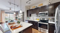 Located at 4020 Koehler St in Houston, TX, this one-bedroom, one-bathroom residence offers a thoughtfully designed layout across a single floor. The open-concept kitchen is a standout feature, showcasing rich dark cabinetry, a subway tile backsplash, stainless steel appliances, and a large quartz-topped center island with bar seating — all illuminated by sleek pendant lighting and a track lighting system overhead. Warm hardwood floors flow throughout the main living areas, adding depth and character to the space.

The living room offers a welcoming atmosphere with access to a private balcony through a sliding glass door, inviting natural light and outdoor views. The bedroom features plush carpeting, a bold accent wall, and generous windows that allow ample natural light to fill the room. A dedicated walk-in closet provides well-organized shelving and hanging space.

The bathroom is finished with large-format floor tiles, a soaking tub with shower, and clean, neutral tones that create a calm and functional space. Throughout the residence, the high ceilings contribute to an open, airy feel, making the most of the efficiently designed floor plan.