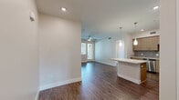 Located at 15101 Fairfield Ranch Rd in Chino Hills, CA, this single-story, 3-bedroom, 2-bathroom home offers a well-designed layout across a comfortable footprint. The open kitchen and living area serves as the heart of the home, showcasing light wood-toned cabinetry, a textured tile backsplash, quartz countertops, and a full suite of stainless steel appliances including a gas range, built-in microwave, dishwasher, and French door refrigerator. A central kitchen island provides additional prep and seating space, while teardrop pendant lights add a modern touch overhead. Wood-look plank flooring runs consistently throughout the main living areas, lending warmth and cohesion to the space. The spacious primary bedroom benefits from natural light and direct outdoor access through a glass door, complemented by a ceiling fan. The additional bedrooms are well-proportioned, each with ceiling fans and windows that bring in natural light and outdoor views. Both bathrooms feature clean, white tiled tub-shower combinations with brushed nickel fixtures and wood-look flooring. The home also includes a dedicated closet and two hallways connecting the layout efficiently. An attached single-car garage with a windowed door provides convenient parking and additional storage.