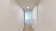 Located at 1 Hawaii Ave NW in Washington, DC, this thoughtfully designed 3-bedroom, 2-bathroom unit offers a clean, modern aesthetic across a single floor. Light wood-style flooring runs throughout, complementing the bright, neutral walls that create a cohesive and airy atmosphere.

The kitchen is a standout feature, equipped with slate-gray shaker-style cabinetry accented by matte black hardware, crisp white quartz countertops, and a classic white subway tile backsplash. Black stainless GE appliances — including a range, over-the-range microwave, and dishwasher — add a contemporary edge. The kitchen opens directly to the living area, creating a connected and functional common space.

The living room benefits from large windows that invite generous natural light and offer outdoor views of surrounding greenery. The three bedrooms are well-proportioned, with the spacious primary bedroom providing ample room for comfortable furnishings. Select bedrooms include double-door closets for added storage.

Both bathrooms are finished with large-format light tile flooring and feature dark-toned vanity cabinetry with white countertops. One bathroom includes a tiled shower surround, while the second features a window for natural light. A central hallway connects all rooms efficiently, completing this clean and contemporary floor plan.