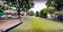 This residential property, situated at 61 Gordon Blvd in Occoquan, VA, is a well-designed two-story complex that seamlessly blends living spaces with outdoor amenities. The exterior features brick construction, giving it a solid and classic appearance. The complex is surrounded by lush greenery, with mature trees providing shade and enhancing the overall aesthetic.

A standout feature is the dedicated playground area, complete with modern equipment including slides and climbing structures. The playground is set on a bed of wood chips for safety and is bordered by a raised edge, separating it from the surrounding grassy areas.

The property boasts expansive lawn areas, perfect for outdoor activities or relaxation. These green spaces are well-maintained and enclosed by black metal fencing, offering a sense of security and definition to the outdoor areas. Concrete pathways wind through the grounds, providing easy access to various parts of the complex.

Ample parking is available, with a spacious lot featuring marked spaces for residents and visitors. The parking area is conveniently located close to the residential buildings, ensuring easy access for tenants.

The complex's layout promotes a community feel, with shared outdoor spaces that encourage interaction among residents. Additional amenities include outdoor seating areas, such as benches placed along the pathways, offering spots for rest and socializing.

Overall, this property combines comfortable living with a range of outdoor amenities, creating an inviting residential environment in a suburban setting.