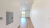 Located at 3875 W Dobbins Rd, Unit 1053, in Laveen, Arizona, this 400-square-foot studio apartment offers a thoughtfully designed single-floor layout that maximizes functionality. The open-concept kitchen and living area form the heart of the unit, featuring light wood-look plank flooring that extends throughout the entire space, creating a cohesive and airy feel. The kitchen is well-appointed with light wood cabinetry, granite-style countertops, a white tile backsplash, and a full suite of stainless steel appliances including a refrigerator, range, over-the-range microwave, and dishwasher. A ceiling fan overhead serves the living area, which is brightened by a sliding glass door that opens to a private patio, allowing natural light to fill the room and providing outdoor views of the surrounding neighborhood. The bathroom features a wood-toned vanity with granite-style countertop, a large mirror, and a full soaking tub with shower combo finished in clean white surroundings. The unit's crisp white walls, modern fixtures, and consistent flooring throughout give the space a clean, contemporary ambiance well-suited for efficient, comfortable living.