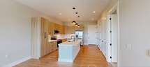 Located at 4362 Watermark Dr in Wilmington, NC, this modern 1-bedroom, 1-bathroom unit offers 760 square feet of thoughtfully designed living space on a single floor. The open-concept kitchen and living area serves as the heart of the home, featuring light wood-grain cabinetry, a large center island with a white quartz countertop and undermount sink, stainless steel appliances including a French door refrigerator, electric range, and microwave, complemented by stylish dome pendant lighting and light hardwood-style flooring. The living room opens directly to a private balcony through a glass-panel door and large windows, offering expansive views of a pond and the surrounding landscape. The spacious bedroom spans 190 square feet, featuring plush carpeting, a ceiling fan, and a window framing natural views of open marshland. The bathroom is finished with wood-toned cabinetry, a glass-enclosed shower, and black hardware accents, with direct access to a well-organized walk-in closet with built-in shelving. Clean neutral walls and consistent modern finishes throughout give the unit a bright, cohesive aesthetic.