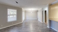 This single-floor, one-bedroom, one-bathroom residence offers a thoughtfully designed layout with a clean, neutral aesthetic throughout. The open living area features wood-look laminate flooring, crown molding, a textured ceiling, and multiple windows with blinds that allow natural light to fill the space. A pendant light fixture serves as a subtle focal point, enhancing the open feel of the combined living and dining area.

The kitchen is appointed with white cabinetry, granite countertops, a classic subway tile backsplash, and stainless steel appliances, including a full-size refrigerator. The flooring transitions seamlessly from the main living area, maintaining a cohesive design.

The bedroom is carpeted for comfort, features a ceiling fan with light, a window for natural light and ventilation, and provides access to a dedicated walk-in closet equipped with wire shelving for organized storage.

The bathroom includes a full-size soaking tub and shower combination with chrome fixtures, set against neutral-toned walls. Throughout the residence, consistent use of soft gray and beige tones, white trim, and modern hardware contributes to a clean, move-in-ready atmosphere well-suited for comfortable everyday living.