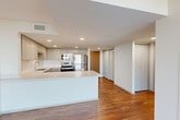 Located in Lincoln, Nebraska, this thoughtfully designed single-floor residence offers a cohesive and functional layout across its living spaces. Rich hardwood flooring flows throughout, anchoring the clean, modern aesthetic found in every room.

The open-concept kitchen, dining, and living area serves as the heart of the home. The kitchen is well-equipped with a full suite of stainless steel appliances — including a refrigerator, range, microwave, and dishwasher — complemented by sleek gray cabinetry, white stone countertops, a tile backsplash, and a generous island with additional storage and prep space. Recessed lighting illuminates the area effectively.

The living room is bright and airy, anchored by a floor-to-ceiling sliding glass door that opens to the patio, offering expansive outdoor views and abundant natural light. Dark panel curtains provide contrast and privacy. The bedroom offers a comfortable footprint, supported by three closets providing ample storage throughout the unit.

A hallway connects the private areas of the home, maintaining a clear separation between living and sleeping spaces. The overall design is contemporary and minimal, with a neutral color palette, clean lines, and consistent finishes that create a cohesive, move-in-ready environment.