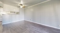 Located at 2104 S Lewis St in Anaheim, California, this well-appointed one-bedroom, one-bathroom unit offers a functional and cohesive layout designed to maximize every square foot. Throughout the space, wood-look luxury vinyl flooring in a warm gray tone creates a clean, modern aesthetic that ties each room together seamlessly.

The living room is bright and open, featuring crown molding, a ceiling fan with light fixture, and soft gray walls that lend a calm, neutral ambiance. A sliding glass door opens directly onto a private balcony, flooding the space with natural light and offering pleasant outdoor views of surrounding greenery.

The kitchen is efficiently designed with white shaker-style cabinetry, granite-look countertops, a gas range, and a peninsula that provides additional prep and serving space. A built-in pantry area adds practical storage. The kitchen opens toward the living area, creating a connected, airy feel.

The bedroom is a comfortable, well-proportioned retreat with a large window that invites natural light and views of mature trees outside. The room offers ample space for furnishings and features the same consistent flooring and cool-toned wall paint found throughout.

The bathroom includes a full tub-shower combination with white tile surround, a vanity with granite-look countertop, white cabinetry, and wood-look flooring, maintaining the clean and cohesive design of the overall space.