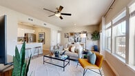 This thoughtfully laid-out 2-bedroom, 1-bathroom residence offers a seamless blend of modern design and functional living across a single floor. The open-concept living and dining area serves as the heart of the home, featuring light wood-style flooring, neutral-toned walls, and a ceiling fan that enhances the bright, airy atmosphere. Large windows allow natural light to fill the space, creating an inviting and comfortable environment.

The kitchen is a standout feature, outfitted with crisp white cabinetry, quartz countertops, a grey tile backsplash, stainless steel appliances, and a peninsula with bar seating — ideal for both cooking and casual dining. A pendant light adds a refined finishing touch overhead.

The primary bedroom is generously sized, offering ample room for a full furniture arrangement, with natural light streaming through curtained windows and direct access to a walk-in closet complete with wire shelving and organizational storage. The shared bathroom features clean white subway tile in the tub-shower surround, white cabinetry, and wood-style flooring for a cohesive, modern aesthetic.

A dedicated in-unit laundry room houses a full-size washer and dryer. The dining area opens toward a sliding glass door, offering access to an outdoor area with views of the surrounding neighborhood. Two closets provide ample storage throughout.